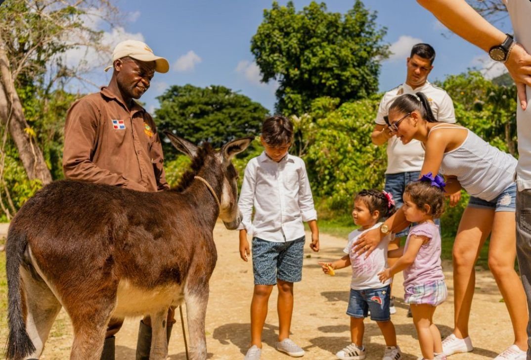 Niños y familias participando en un taller creativo al aire libre durante La Fiesta de la Cosecha en el Parque Central.